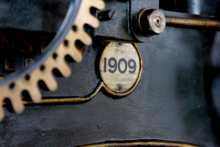 A close-up of the date stamp, a round brass plate, on the Launceston tower clock.