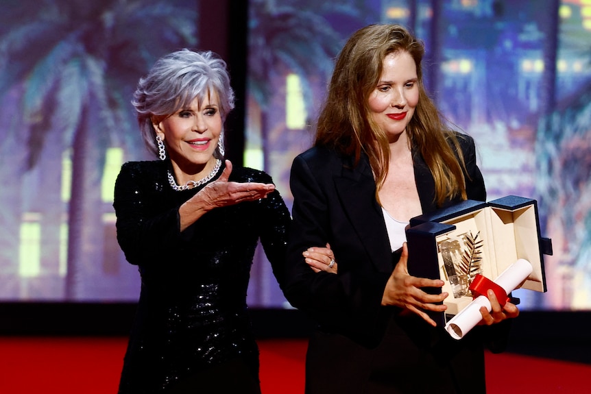 Actor Jane Fonda stands next to director Justine Triet on stage at Canne Film festival.