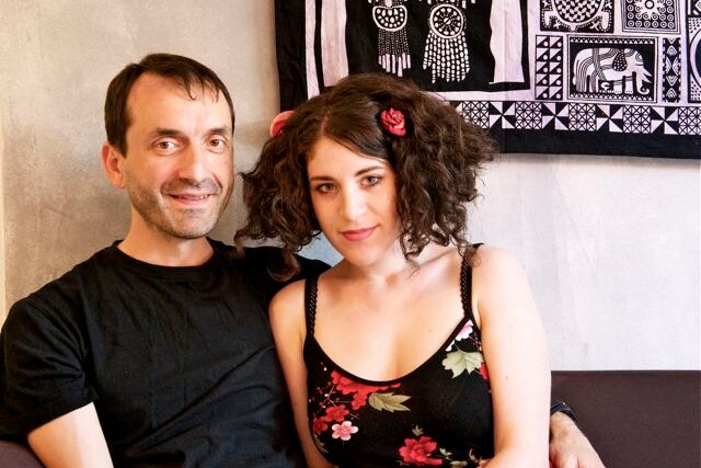 Man with dark hair next to a woman with dark curly hair 