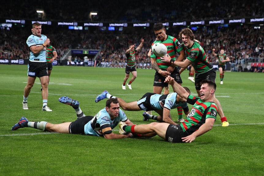 A man celebrates after scoring a try in a semi-final.