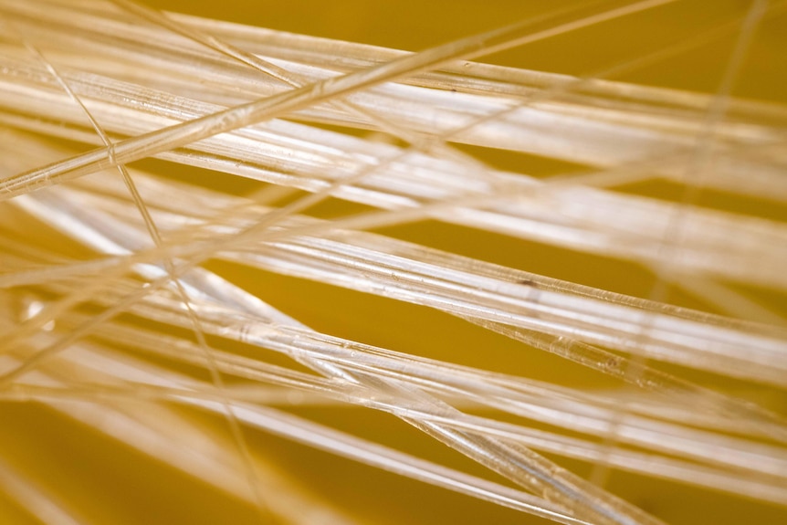 Thin glass-like straws on a yellow background