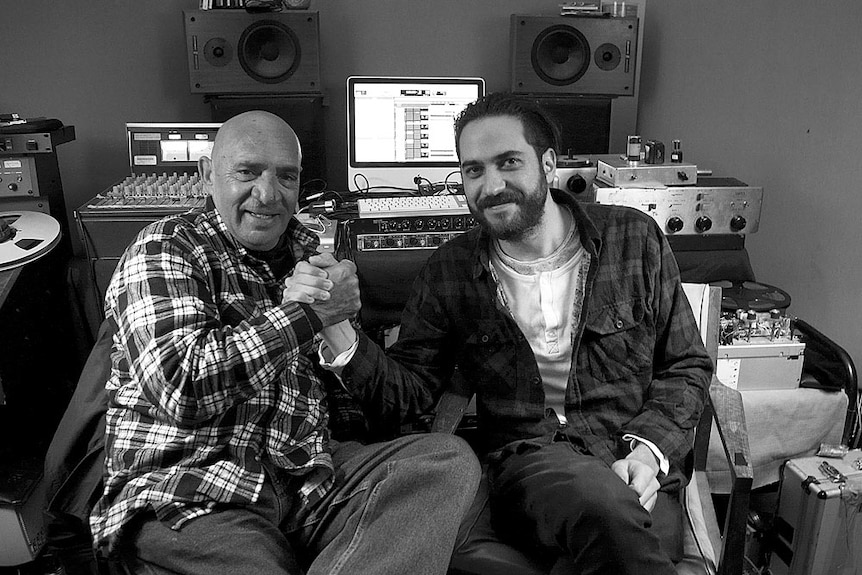 Vic Simms and Luke Peacock grip hands as a show of solidarity in the studio
