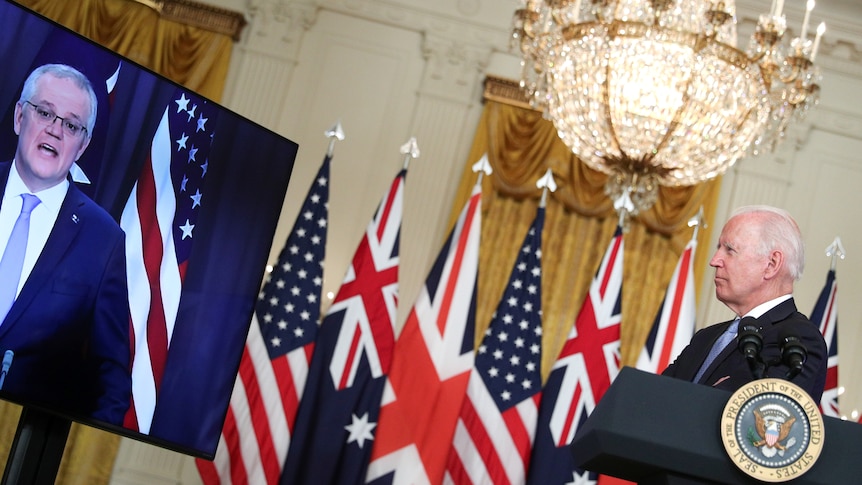 Joe Biden looks at a video screen showing Scott Morrison 