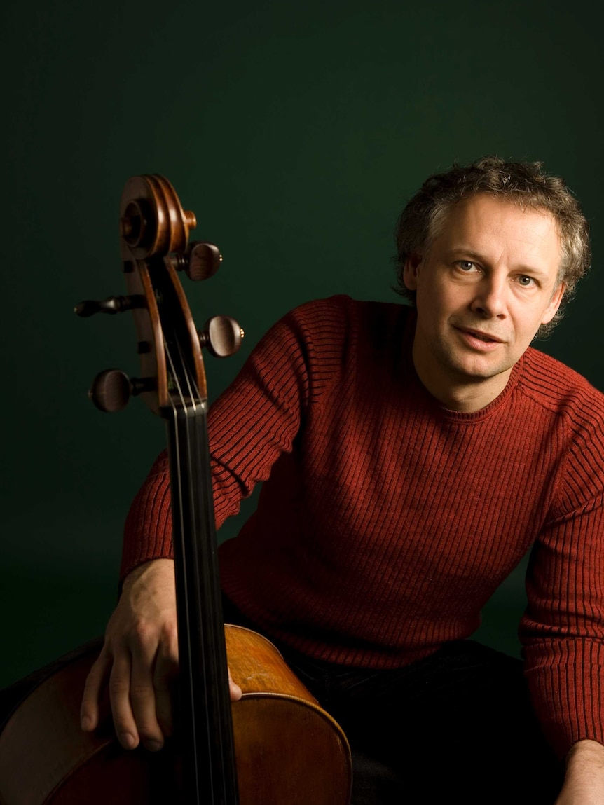Cellist Pieter Wispelwey in a red sweater posing with his cello.