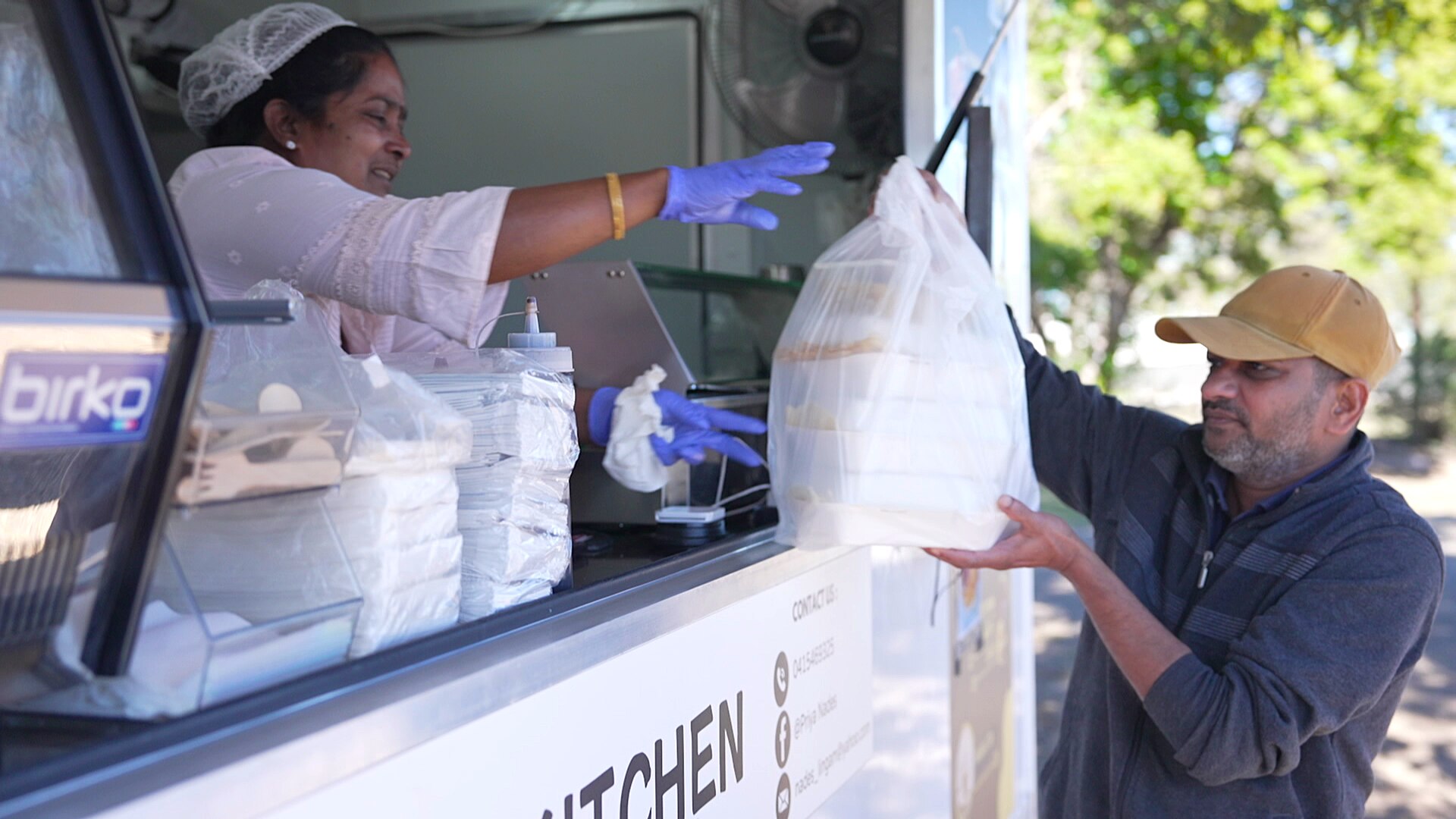 Priya serving a customer at her food truck