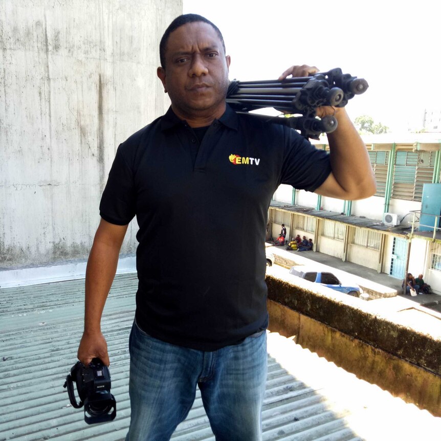 Scott Waide holds a camera on a roof in Papua New Guinea