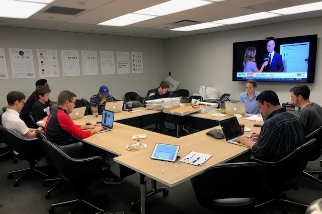 Sports Illustrated editors and producers sit around a table eating pizza as they prepare for NBA drafts.