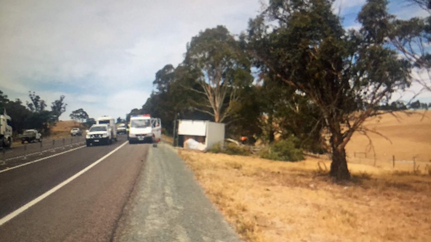 A truck on its side next to the Midlands Highway.