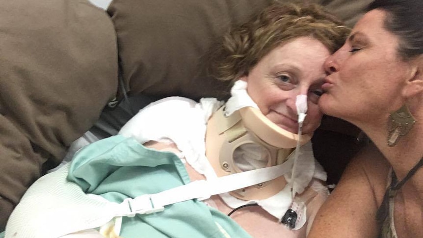 Donna Sallfeld kisses Dawn Weldon on the forehead in her thai hospital bed.