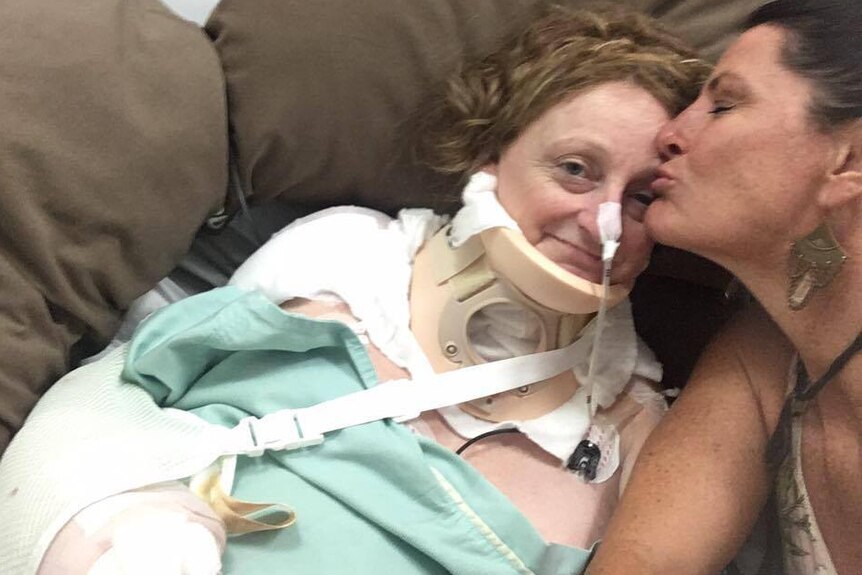 Donna Sallfeld kisses Dawn Weldon on the forehead in her thai hospital bed.