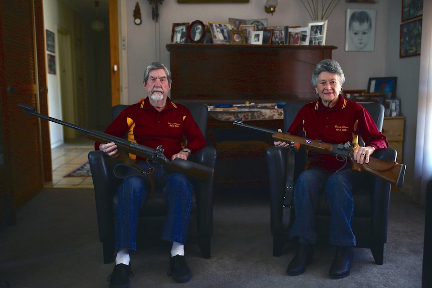 Betty Concanen and husband Merv sitting on chairs with their rifles resting across their laps.