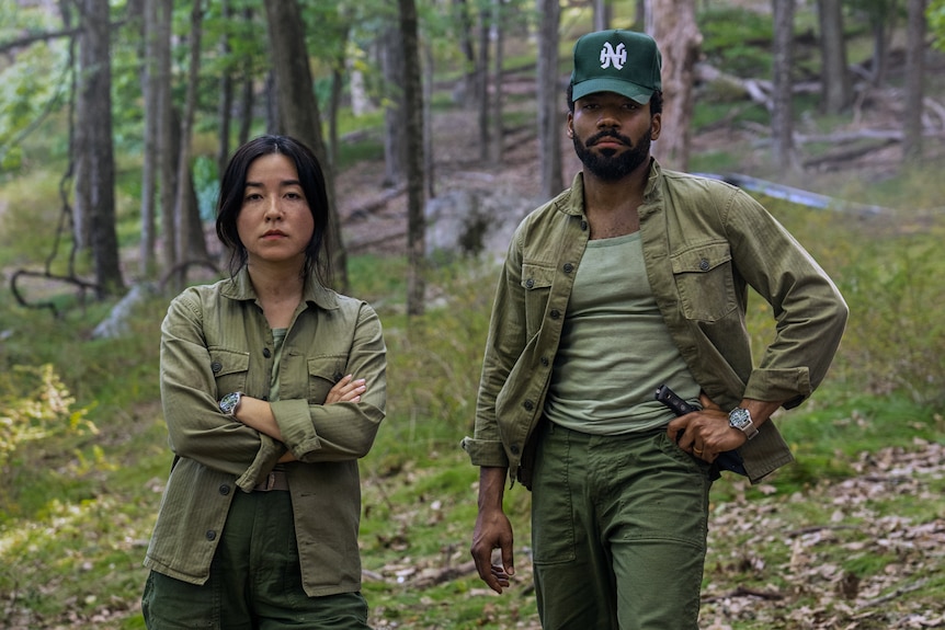 Maya Erskine and Donald Glover outdoors in camouflage as Mr & Mr Smith 