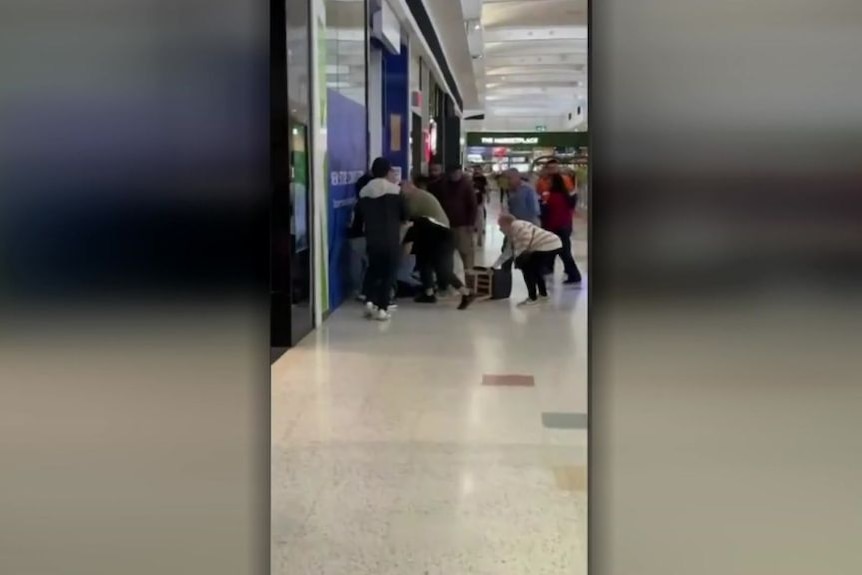Screengrab from mobile vision of a crowd of people in shopping centre.