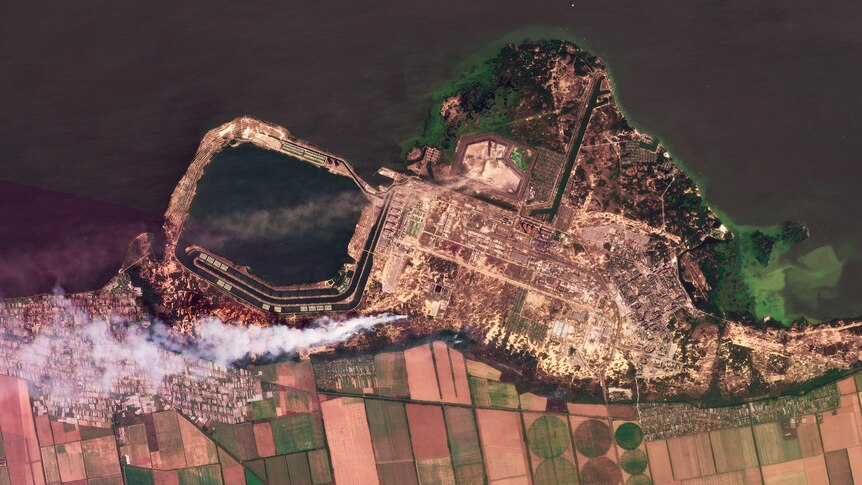 A composite of satellite images shows smoke rising from fires at a nuclear power plant.