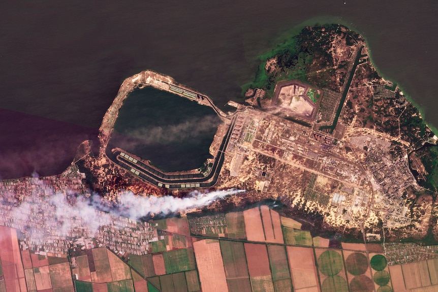 A composite of satellite images shows smoke rising from fires at a nuclear power plant.