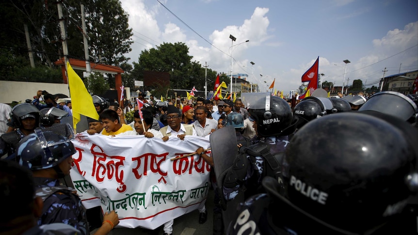 Nepalese activists protesting the new constitution attempt to break through police lines.