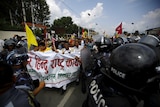 Nepalese activists protesting the new constitution attempt to break through police lines.