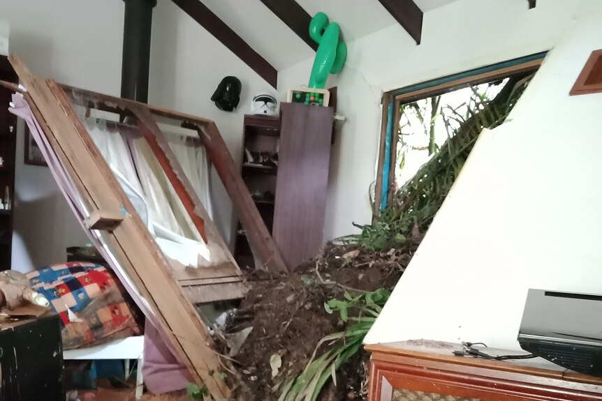 A landslide burst through a wall into a home, knocking over walls and destroying furniture.