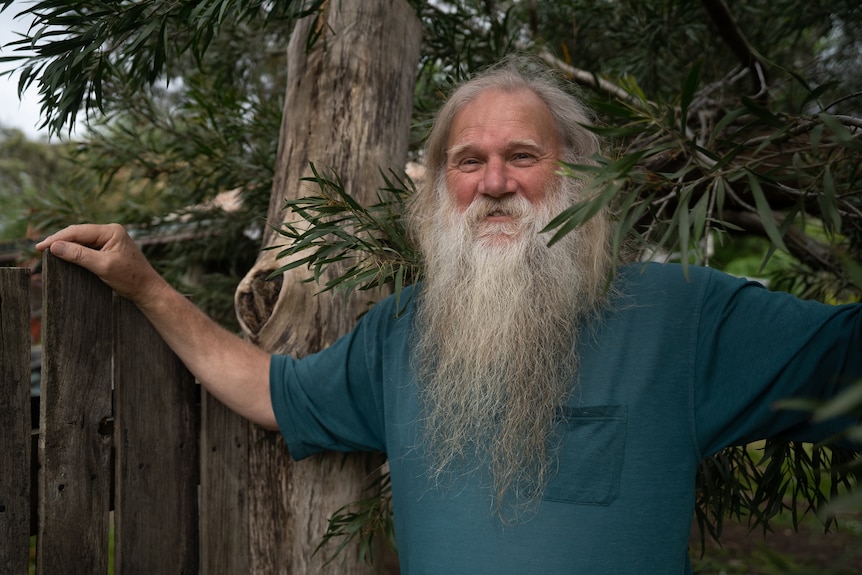 a man with a big bushy beard smiles at the camera.