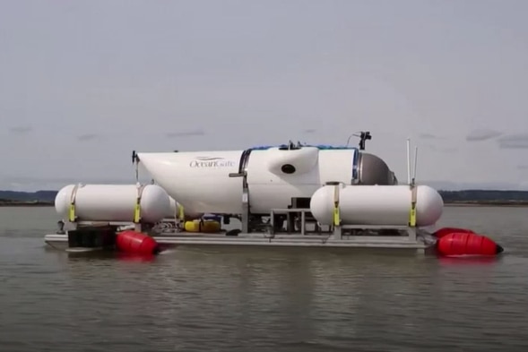 A white submersible vessel floating on a platform on water. 