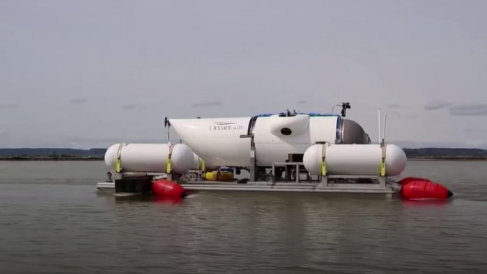 A white submersible vessel floating on a platform on water. 