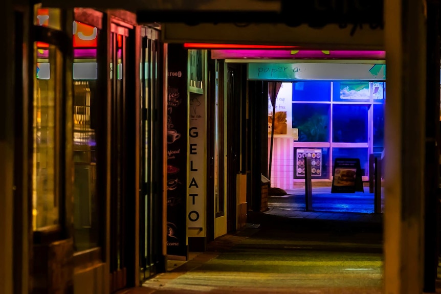 The path along a string of shops at night is completely empty