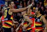 Both smiling, Taylor Walker and Eddie Betts high-five as they run past each other.