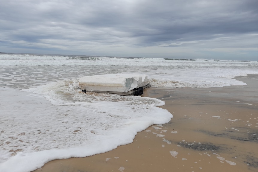 A large block of polystyrene block floats in the shallows at Peregian Beach