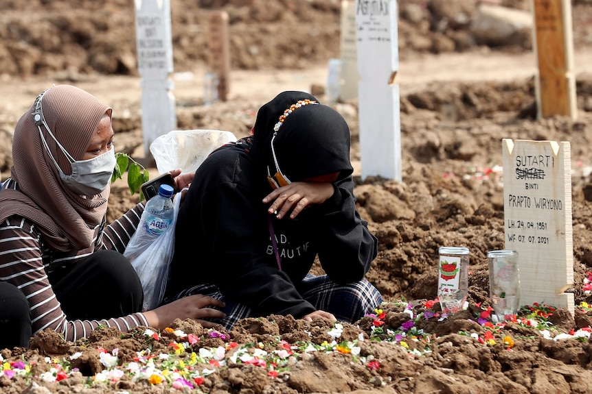 A woman weeps as she visits the grave of a relative