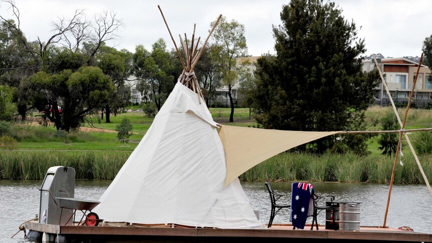 A teepee is set up on a floating platform on Lake Ginninderra