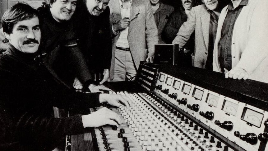 Audio mixing desk surrounded by jazz band musicians in Hobart, 1983.