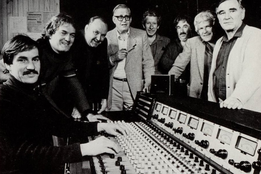 Audio mixing desk surrounded by jazz band musicians in Hobart, 1983.