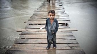 A Pakistani child surrounded by floodwaters (Behrouz Mehri, AFP)
