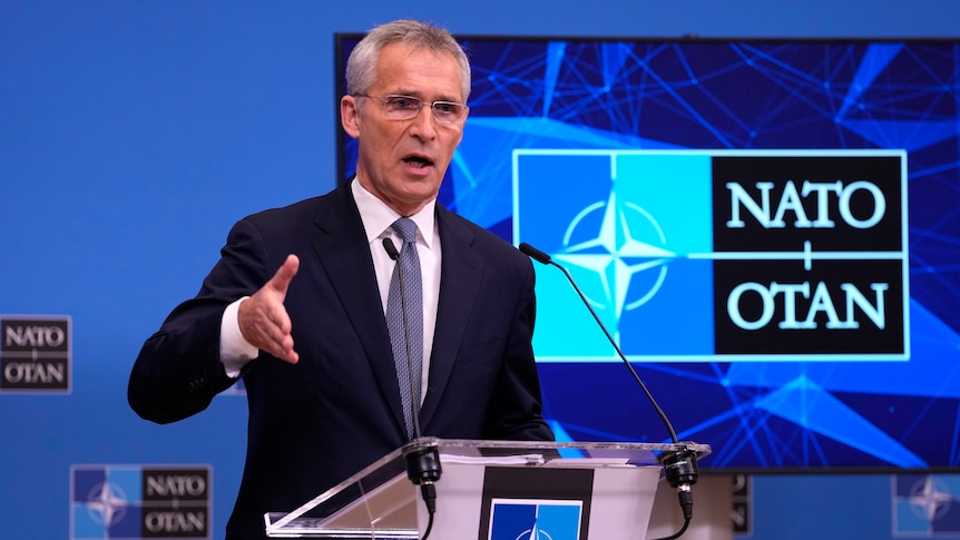 Man in a suit gives a speech from a podium.