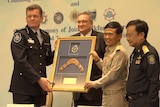 AFP Commissioner Andrew Colvin presenting a framed boomerang to Thailand's Justice Minister, General Paiboon Koomchaya.