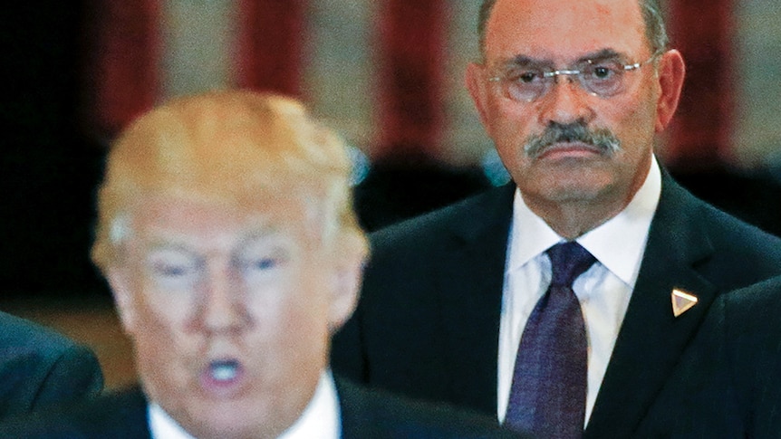 Allen Weisselberg stands behind Donald Trump