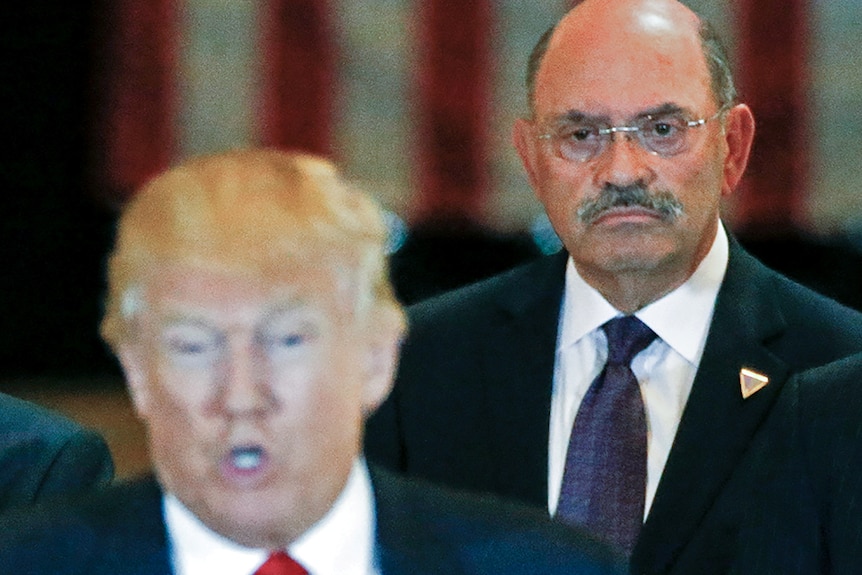 Allen Weisselberg stands behind Donald Trump