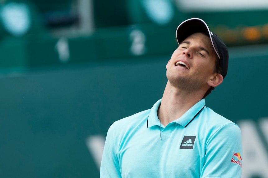 Dominic Thiem looks up, closes his eyes and opens his mouth in a frustrated look