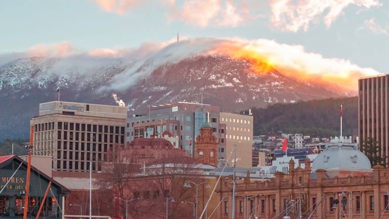 A snow-capped kunanyi/Mount Wellington rises behind Hobart's waterfront.