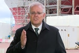 Morrison speaks to the press in front of a ship in Glasgow.