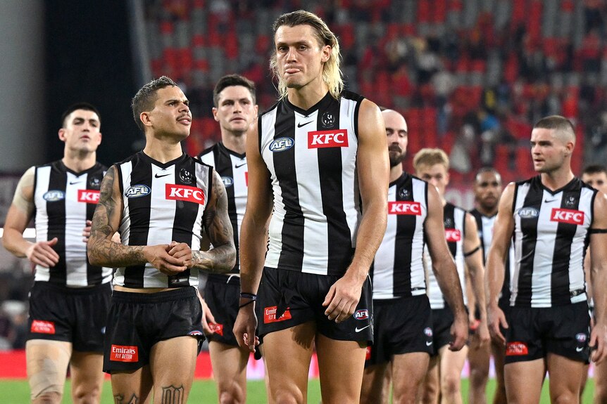 Collingwood walk off the field after AFL loss to Gold Coast.