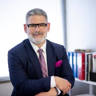 A man with glasses wearing a suit