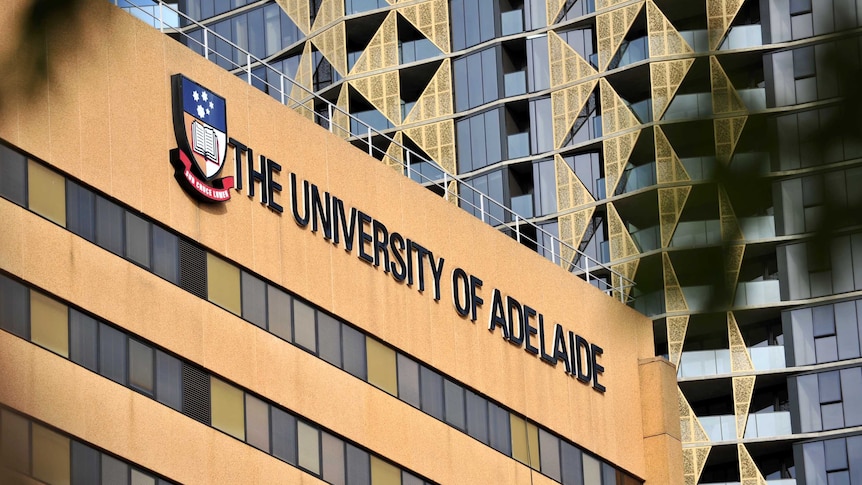 A building with a University of Adelaide sign on it with a taller one in the background