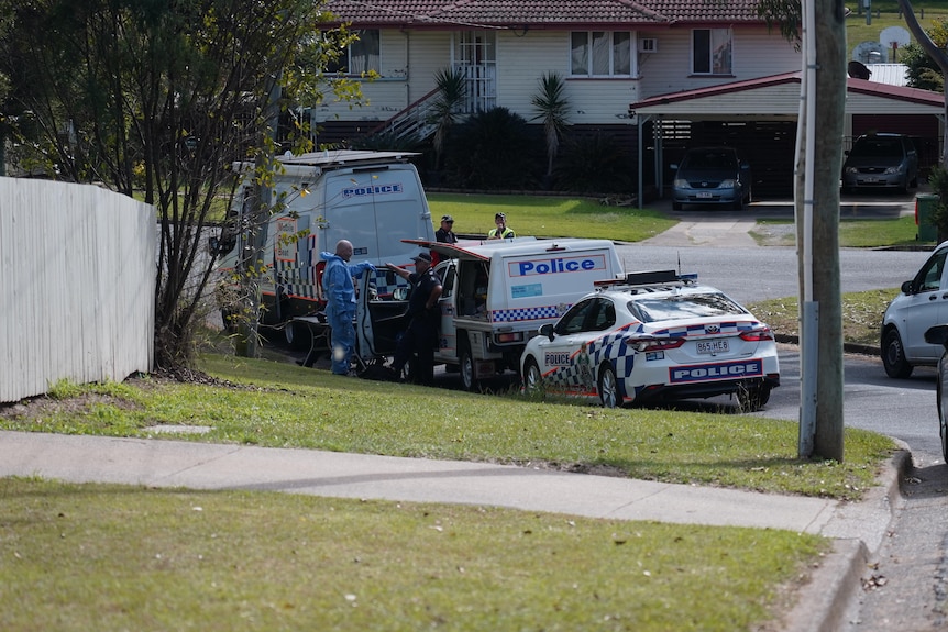 Police vehicles parked along a residential street.