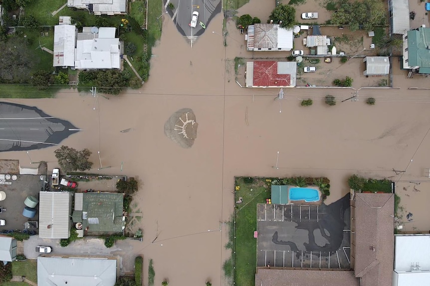 Houses surrounded by brown floodwater.