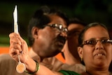 An Indian woman holds a knife distributed by Shiv Sena.