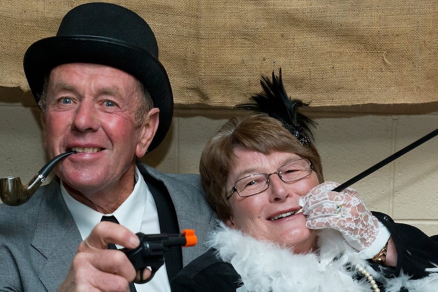 A man and a woman in gangster fancy dress clothes