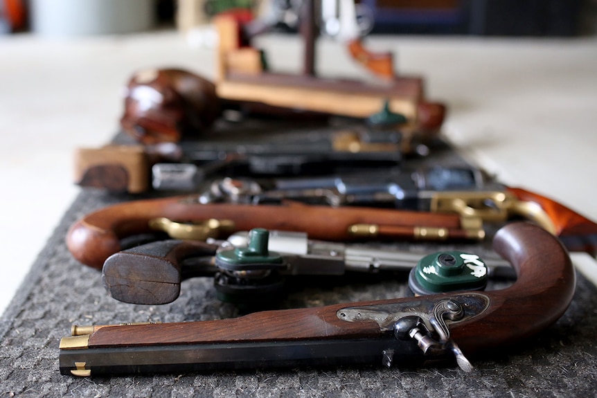 Collector's item hand guns and pistols laid out.