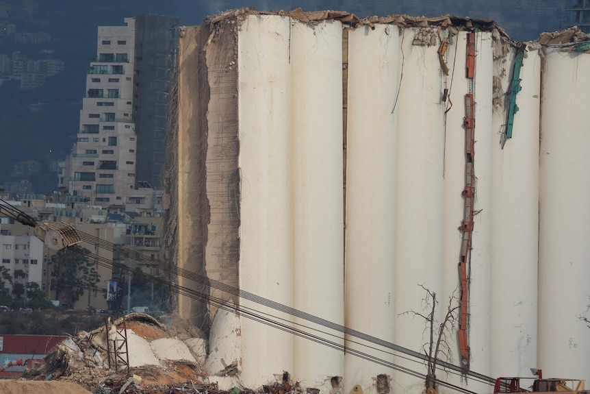 La vista muestra un silo de grano parcialmente derrumbado con escombros en el suelo.