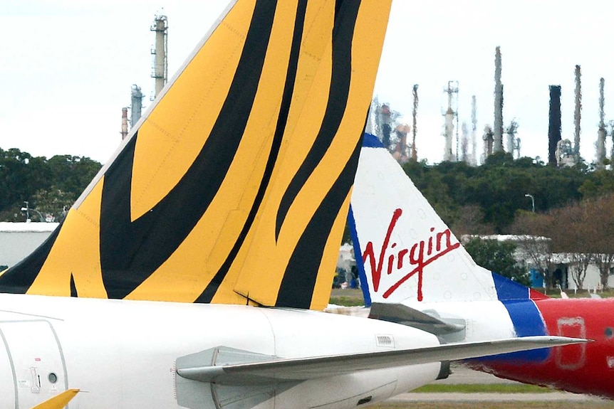 Virgin Australia and Tiger Airways planes pass each other.